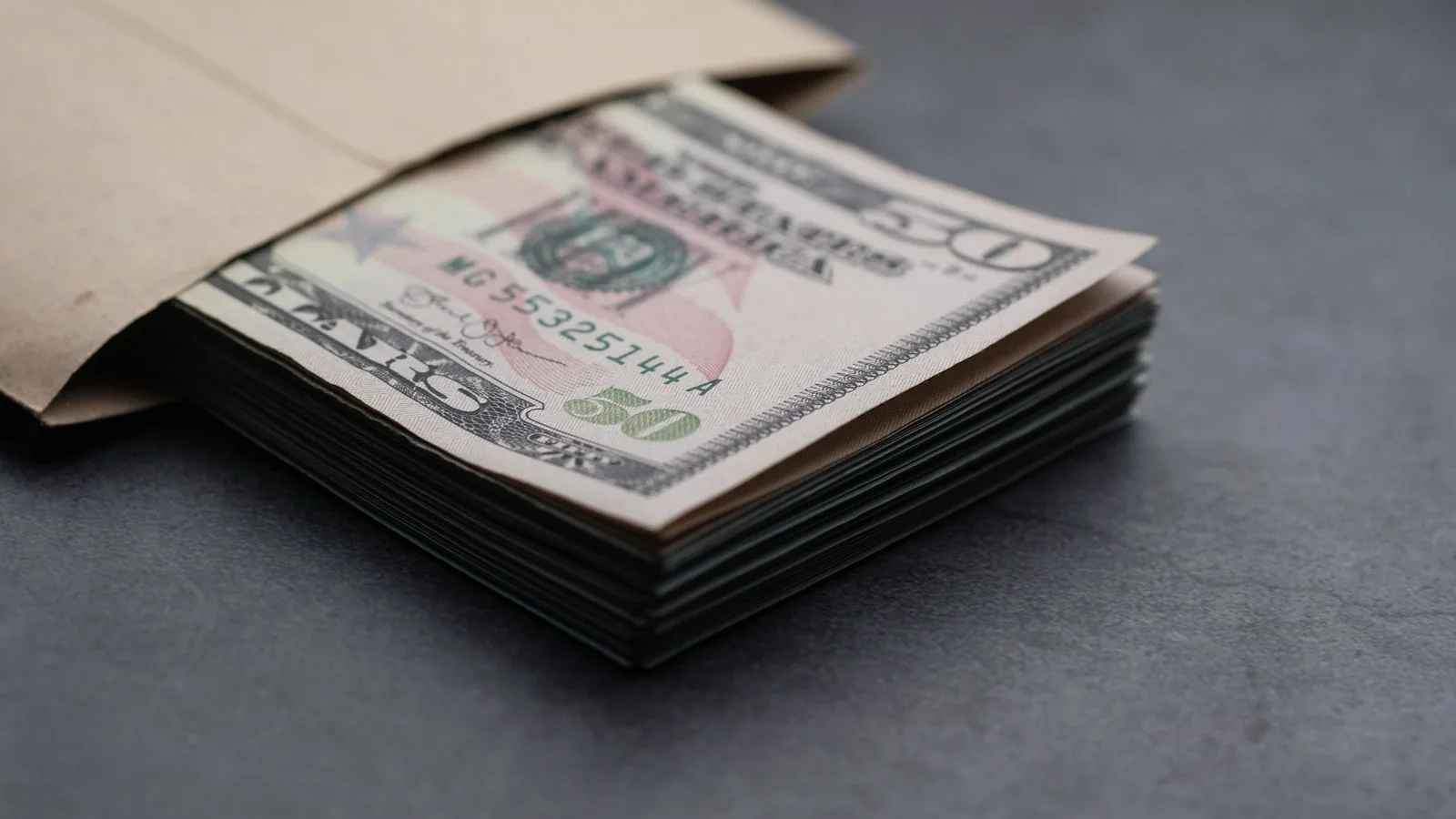 Maço de notas de dólar empilhadas, representando a premiação milionária da Copa do Mundo