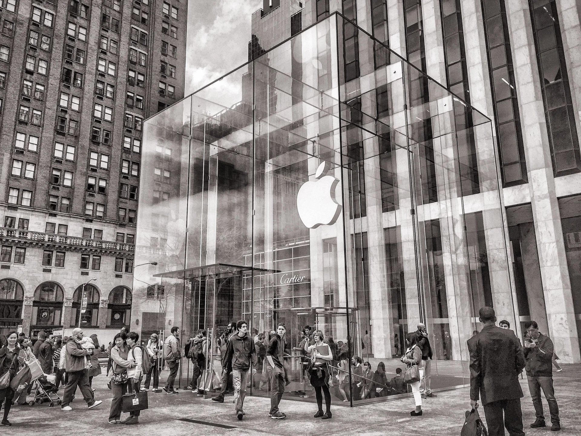 Cubo de vidro da Apple Store da Quinta Avenida, em Nova York, com pedestres ao redor