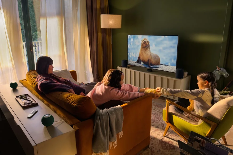 Sala de estar com Apple TV 4K e caixas HomePod compondo sistema de cinema