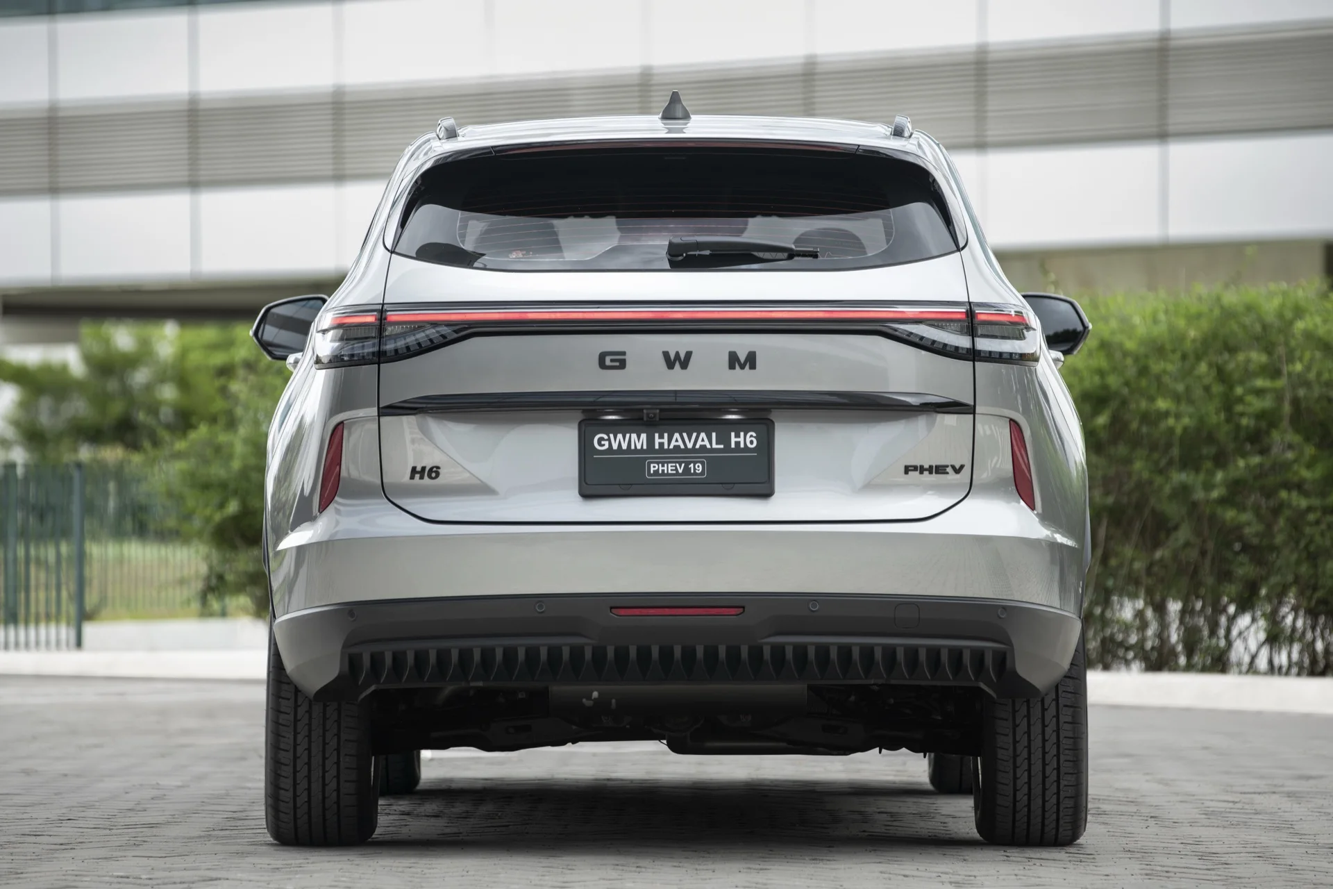 Traseira do GWM Haval H6 PHEV19 com lanternas ligadas por uma barra de luz, letreiro GWM e emblemas H6 e PHEV