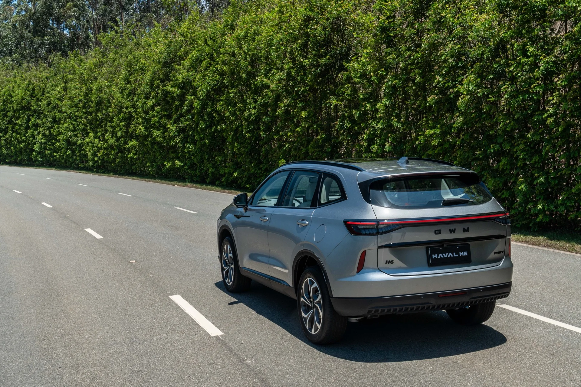 Traseira do GWM Haval H6 PHEV35 Flex cinza rodando em uma estrada