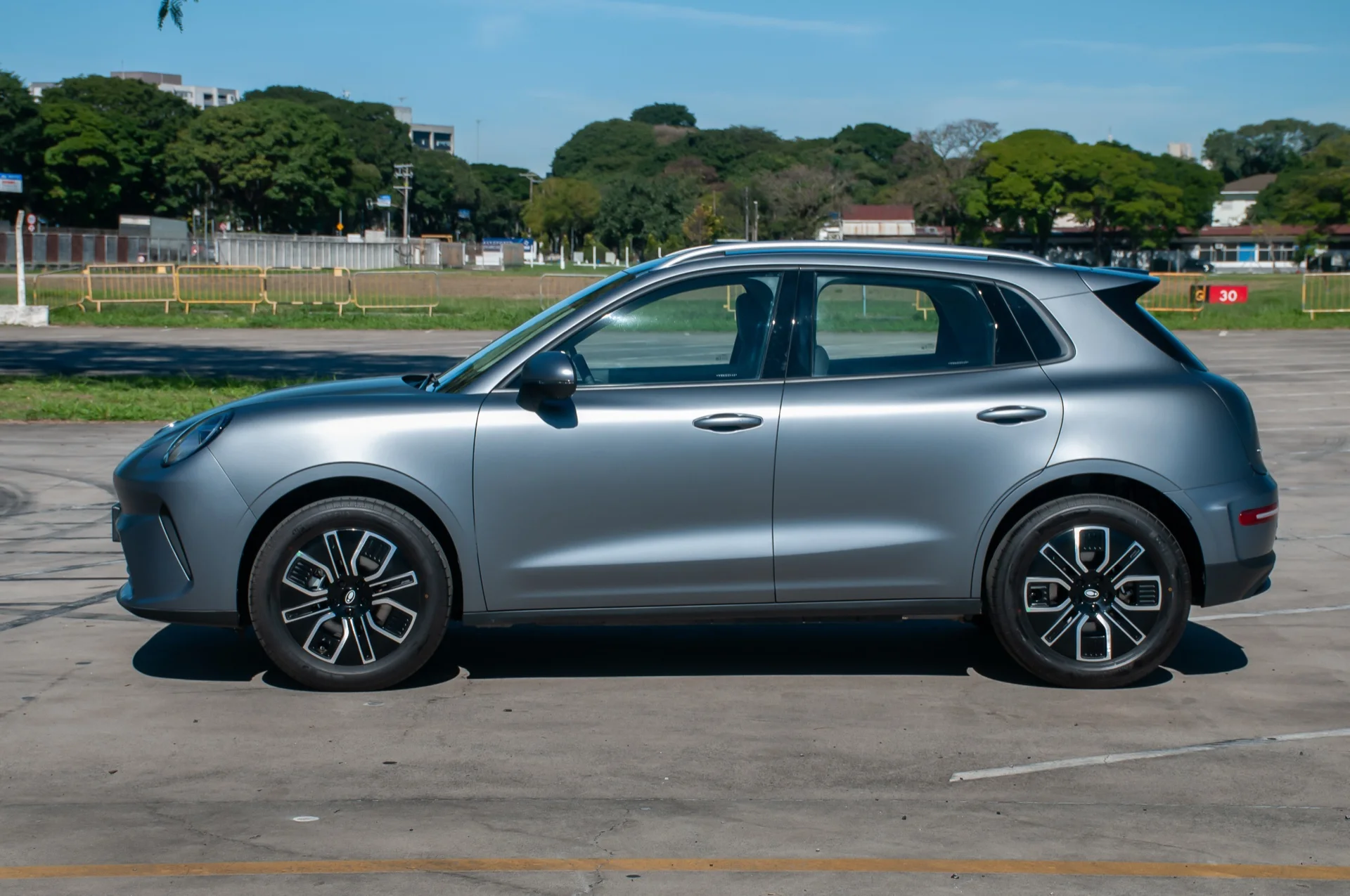 Lateral do GWM Ora 5 cinza estacionado em pátio, com rodas aro 18