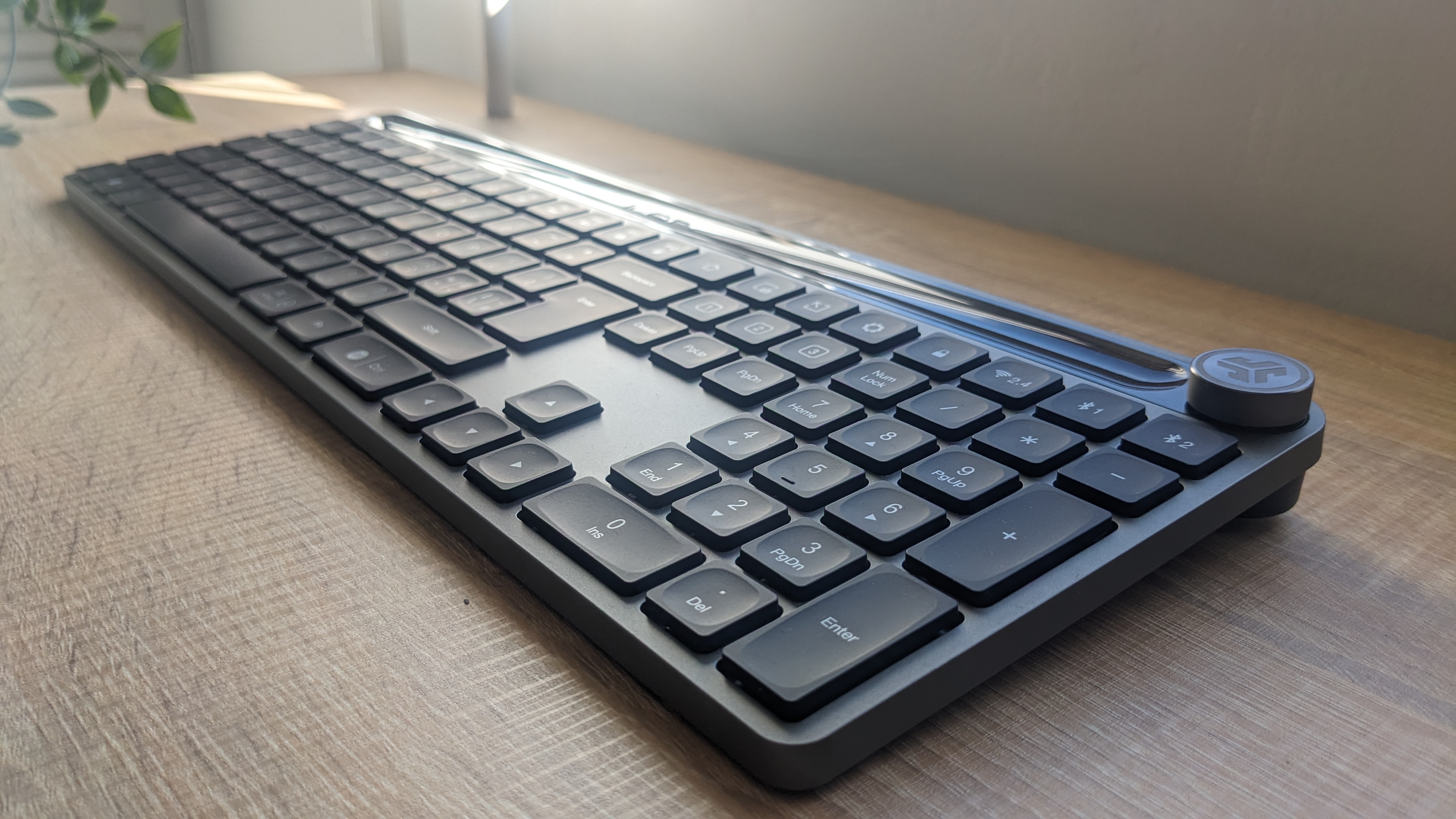 The JLab Epic Wireless Keyboard photographed on a wooden desk.